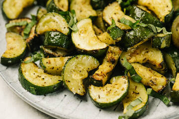 Closeup angled view of a plate of fried zucchini slices - Powered by Adobe