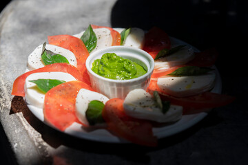 Caprese Salad on a Concrete Surface with Spinach Pesto