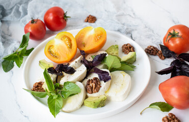 salad with mozzarella, basil, avocado and nuts