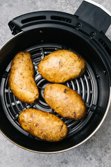 Whole raw golden potatoes in an air fryer