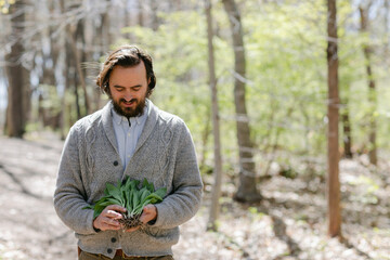 Man smiling down at his fresh foraged ramps in his hand