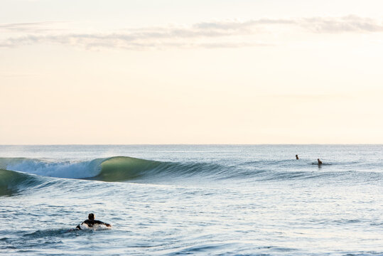 Friends surfing on a glassy day at sunrise