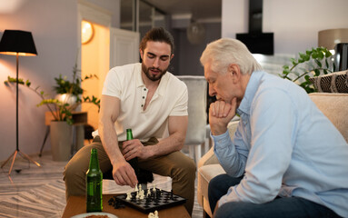 Elderly and young men with beer playing chess