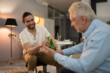 Grandson and grandfather proposing toast after chess game