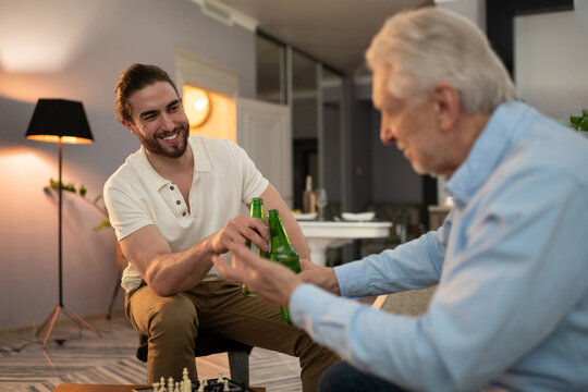 Grandson and grandfather proposing toast after chess game