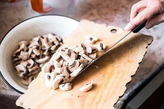 Cooking of mushroom soup. Slicing champignons with a knife