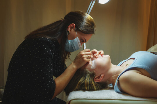 Aesthetic medicine: beauty eyelash extension procedure for a girl