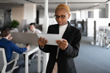Black female manager browsing tablet