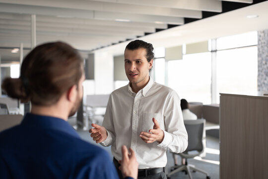 Male colleagues discussing work in office