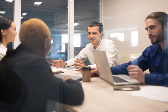 Positive man talking with colleagues during meeting
