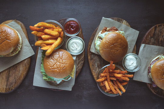 High angle view of various hamburger with french fries served on wooden boards
