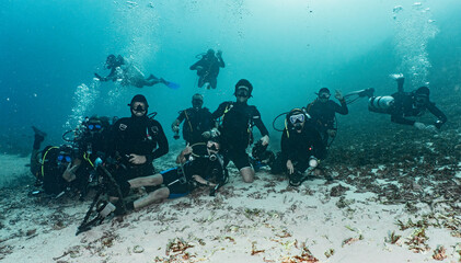 group of friends posing for camera on the ocean floor in Raja Ampat