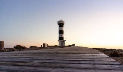 Panoramic low angle view of wood walkway heading towards a lighthouse