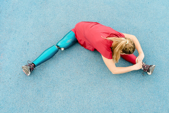 Flexible sportswoman with artificial leg training at stadium