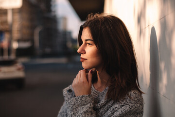 Portrait of thoughtful non-binary woman standing in city