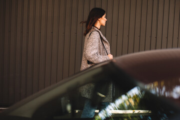 Woman walking against wall on street in city