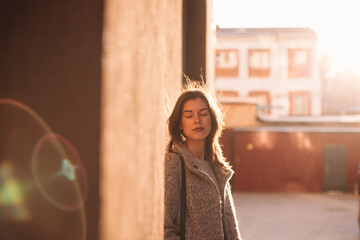 Portrait of young woman with eyes closed standing in city