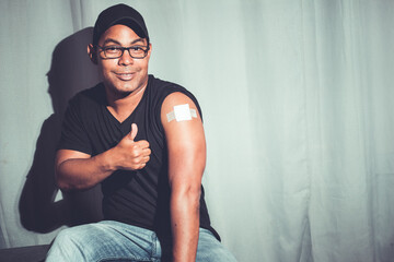 Latino brown man showing arm after covid vaccination