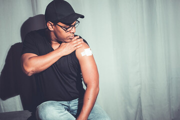 Latino brown man showing arm after covid vaccination