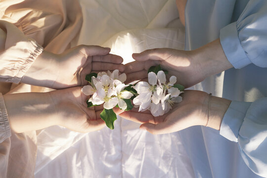 Close up of flowers in the hands of teenagers sitting on the bed