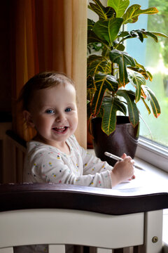 smiling little girl looking at camera while standing in bed