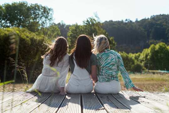 Three unrecognizable girls sitting and enjoying nature