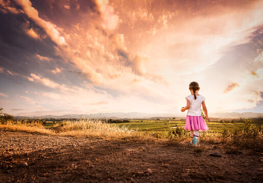 Girls looks out at sunset in summer with amazing sky in France