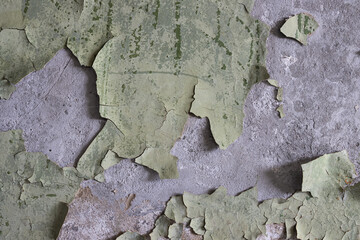 Peeling paint on the wall. Old concrete wall with cracked flaking paint. Weathered rough painted surface with patterns of cracks and peeling. Grunge texture for background and design. High resolution.