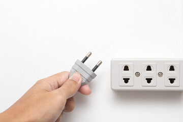 Hands holding plugged and power socket  on white background