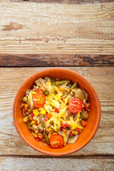 Risotto with mushrooms and cheese in a clay plate on a wooden background.