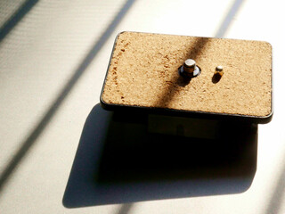 tripod connector to camera presented on sun light with dark shadow reflection.