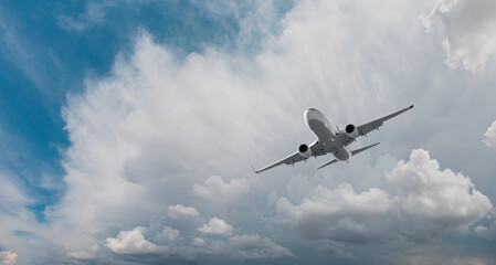 Fototapeta na wymiar A white passenger plane flying over storm clouds