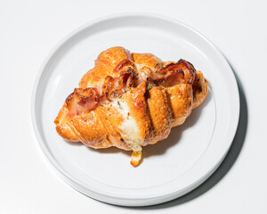 Croissants in a bakery shop. freshly baked croissants with bacon on white plate.