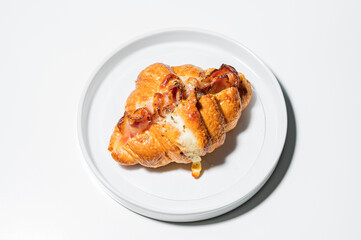 Croissants in a bakery shop. freshly baked croissants with bacon on white plate.