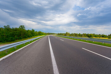 asphalt road under dense cloudy sky
