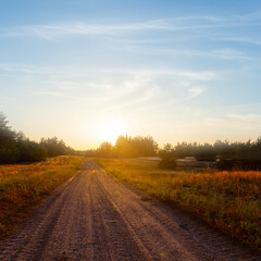 Fototapeta na wymiar ground road among prairie at the sunset