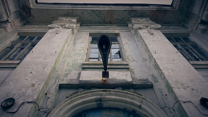Broken lantern on the wall of an abandoned Soviet school.