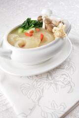 chinese superior double boiled premium shark's fin hot thick soup with crab, prawn and vegetable mushroom with herb in hot stone pot in white background asian halal seafood menu