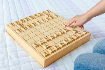 将棋を指す女性、対局開始初手２六歩