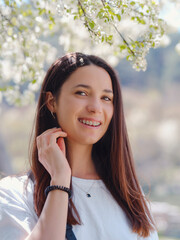 Young smiling brunette woman outdoors portrait.