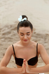 Woman practices yoga and meditates in the lotus position on th ebeach. Beautiful Girl doing yoga.