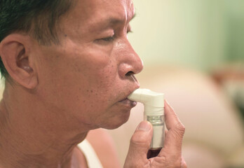 Using a bronchodilator The elderly man was inhaling into the lungs when he had difficulty breathing.