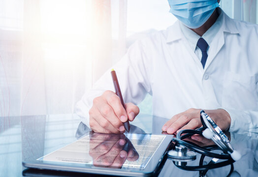 The Doctor Working On Digital Tablet Health Records In The Medical Office. The Concept Is Checking And Taking Care Of Patients' Health Online.