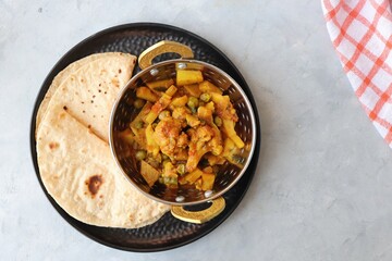 Aloo Gobi Mutter curry, cauliflower, and peas curry. Aloo Gobi masala. Served with wheat roti. famous Indian curry dish with potatoes and green peas. Copy space
