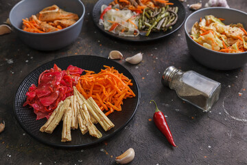 Fermented foods. Assorted Korean pickled salads and home-made fermented vegetables in plates on a dark background. Copy space, Close-up