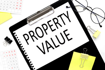 Property Value. text in notepad next to glasses on white background