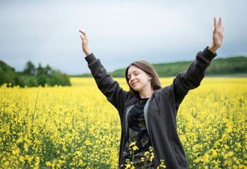 Young girl on yellow rapeseed field