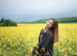 Young girl on yellow rapeseed field