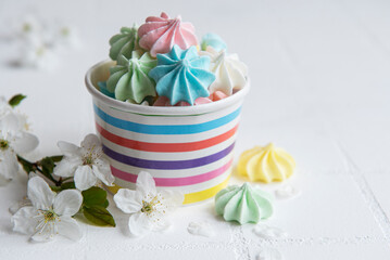 Small colorful meringues in the  paper bowl