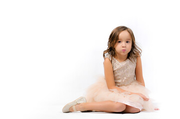 Obraz na płótnie Canvas Portrait of happy pretty curly little girl relaxing, sitting and posing over white background